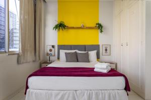 1 dormitorio con 1 cama grande y pared amarilla en Conforto em Ipanema - 2 quadras da praia - VP604 Z1, en Río de Janeiro