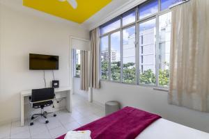 1 dormitorio con 1 cama y escritorio con ordenador en Conforto em Ipanema - 2 quadras da praia - VP604 Z1, en Río de Janeiro