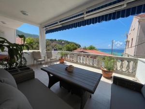 un patio con mesa y vistas al océano en Accommodation Family Magazin, en Žuljana