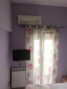 a bedroom with a bed and a window with a television at Casa lungo mare a Thesaloniki in Thessaloniki