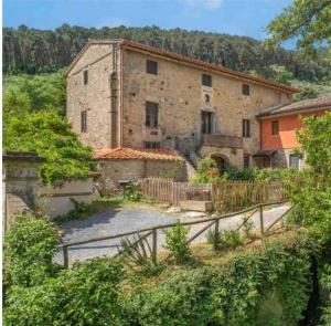 Buti的住宿－Uno spazio di Relax in Toscana，一座大型石头建筑,前面有围栏