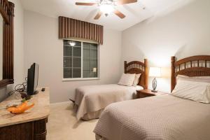 a bedroom with two beds and a flat screen tv at Luxury condo near Wiggins pass beach & park in Naples