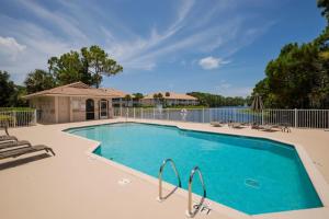 a large swimming pool with chairs and a fence at Luxury condo near Wiggins pass beach & park in Naples