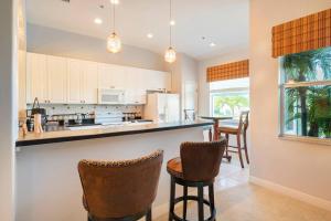 a kitchen with a bar with chairs and a table at Luxury condo near Wiggins pass beach & park in Naples