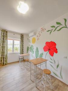 a dining room with a red flower mural on the wall at Metro Guest House in Naples +11 photos