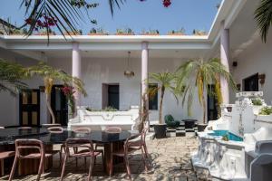 een patio met tafels en stoelen en palmbomen bij HOLT Hotel De Mi Independencia King Room in Oaxaca City