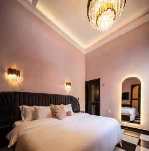 een slaapkamer met een groot bed en een kroonluchter bij HOLT Hotel De Mi Independencia King Room in Oaxaca City