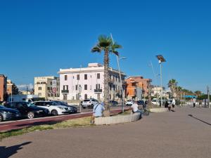 eine Gruppe von Menschen, die auf einer Bank in der Nähe einer Palme sitzen in der Unterkunft Posto al sole in Lido di Ostia