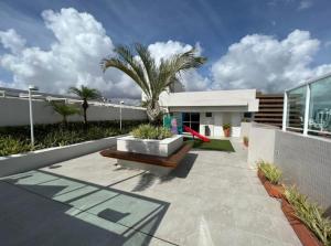 une maison avec un banc et un palmier dans l'établissement Flat na Praia do Bessa Atlântico Norte 303, à João Pessoa