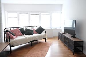 Habitación con cama con almohadas y TV. en Central Apartment Maister en Kranj