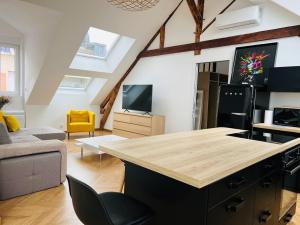 a kitchen and living room with a large island in a loft at Élégant T4 Centre Reims/Parking Privé in Reims