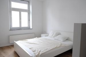 a white bedroom with a bed and a window at Central Apartment Maister in Kranj