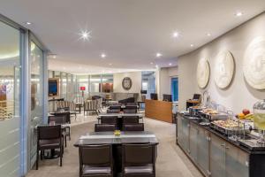 a restaurant with tables and chairs and a cafeteria at Sheraton Asuncion Hotel in Asunción