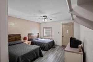 1 Schlafzimmer mit 2 Betten und einem Deckenventilator in der Unterkunft Axtons Bass City Resort in Emory