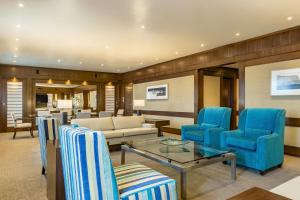 uma sala de estar com cadeiras azuis e um sofá em Sheraton Asuncion Hotel em Assunção