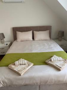a bed with two towels sitting on top of it at M&M Center Apartment with free parking in Plovdiv
