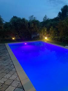 ein blauer Pool in der Nacht mit Lichtern in der Unterkunft Le Mas du Sud in Draguignan