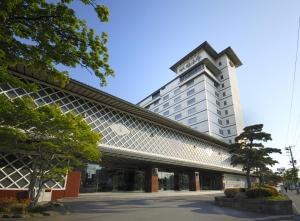 een hotel met een hoog gebouw op de achtergrond bij Takuboku Tei in Hakodate