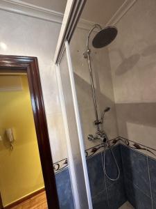 een badkamer met een douche met een douchekop bij Piso Acogedor, en Zona Tranquila y a tan Solo 200 Metros de la Playa y el Centro in Candás