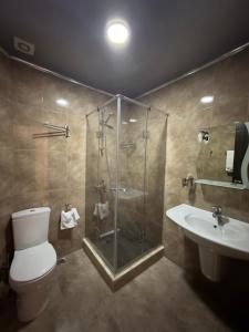 y baño con ducha, aseo y lavamanos. en Hotel Brighton, en Batumi