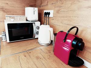 a pink suitcase sitting next to a microwave at Christopher Apartment in Oradea