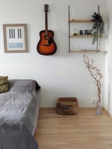 a bedroom with a guitar on the wall and a bed at Toppilansalmi two bedroom apartment with a view in Oulu