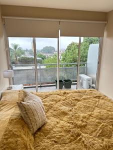 a bedroom with a large bed and a large window at TempoStay Monoambiente in San Miguel de Tucumán