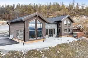 ein Haus mit vielen Fenstern auf einer Auffahrt in der Unterkunft Rindabakkane Lodge in Sogndal