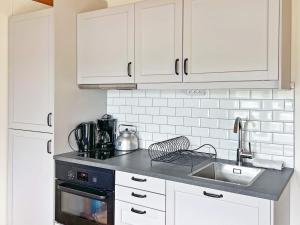 a kitchen with white cabinets and a sink at 4 person holiday home in VÄRMDÖ-By Traum in Värmdö +13 photos