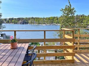 een houten terras met een bank en uitzicht op een meer bij Holiday home VÄRMDÖ V in Värmdö