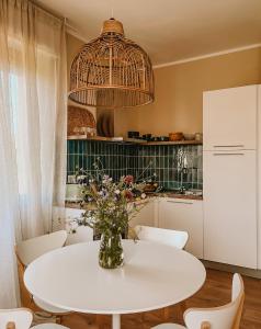 kuchnia z białym stołem z wazonem kwiatów w obiekcie Appartamento il Rosmarino w mieście Portoferraio