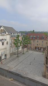 duży dziedziniec z drzewami przed budynkami w obiekcie charmant logement d'Amiens w Amiens