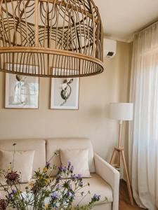 a living room with a couch and a chandelier at Appartamento il Rosmarino in Portoferraio