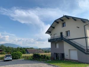 a white house with a balcony on the side of it at l'écureuil, chez le charpentier d'antan, au calme, spacieux T3 duplex, ambiance chalet, vue dégagée et parking privé in Epagny Metz-Tessy