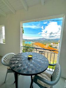 een tafel en stoelen op een balkon met uitzicht bij Résidence Colombara in Cargèse