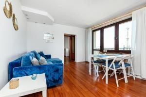 a living room with a blue couch and a table at Prime Home PORTOWY in Gdynia