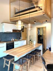 a kitchen with a large wooden table and chairs at Lunette Lodge for 10 guests, 50 m from the lake, sauna, hot tube in Brzozie +70 photos