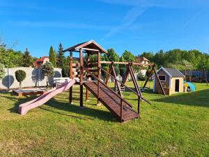 a playground with a slide in a field at Domki letniskowe GOSIA in Żarnowska