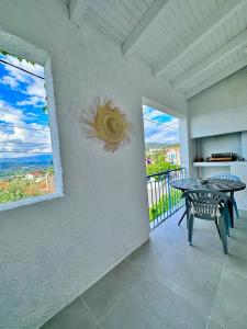 uma sala de jantar com uma mesa e duas janelas em Résidence Colombara em Cargèse