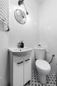 a bathroom with a toilet and a sink and a mirror at Prime Home PORTOWY in Gdynia