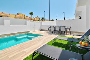 a patio with a swimming pool and tables and chairs at Villa Blanco in San Pedro del Pinatar +67 photos