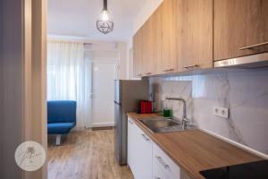 a kitchen with a sink and a blue chair at PALMERA STUDIOS in Ofrínion +10 photos