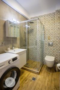 a bathroom with a shower and a washing machine at PALMERA STUDIOS in Ofrínion