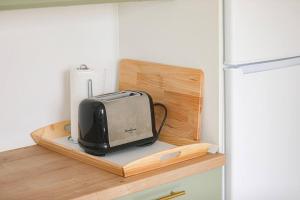 a microwave sitting on a shelf next to a refrigerator at Neue Wohnung in der Nähe von Trier in Korlingen