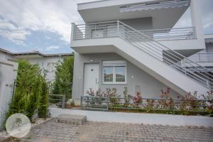 a white house with a balcony and stairs at PALMERA STUDIOS in Ofrínion