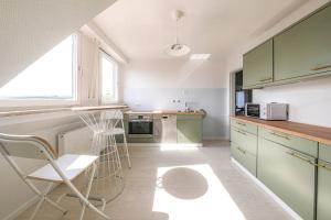 kuchnia z zielonymi szafkami i krzesłem w obiekcie Neue Wohnung in der Nähe von Trier w mieście Korlingen
