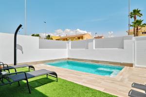 a swimming pool in the backyard of a house at Villa Blanco in San Pedro del Pinatar