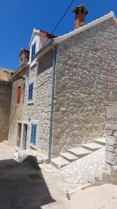 un edificio de piedra con escaleras en su lateral en Kamena Kuca Kaprije, en Kaprije