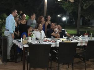 um grupo de pessoas sentadas à volta de uma mesa à noite em Karpaz Lembusa Guest House em Rizokarpaso