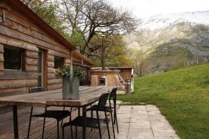 una mesa de madera y sillas frente a una casa en Le Chal'home, montagne et nature en Campan